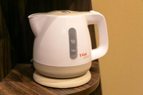 a white mixer sitting on a wooden shelf at IKIDANE Cozy Hotel Haneda Airport in Tokyo