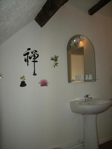 a bathroom with a sink and a mirror at Au Nid de Tillé in Tillé