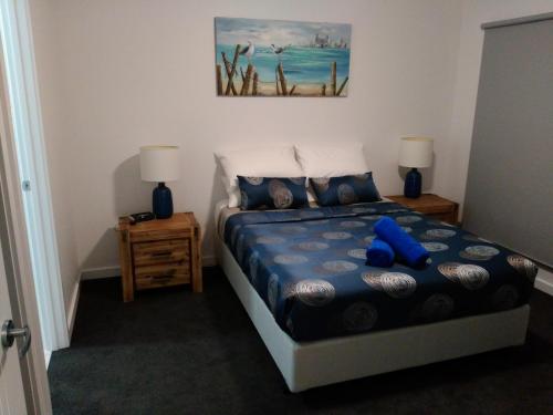 a bedroom with a blue teddy bear sitting on a bed at Laguna View in Port Lincoln