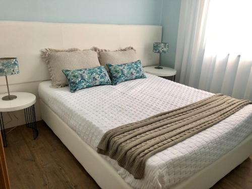 una camera da letto con un letto bianco con due tavoli e due lampade di Casa da Miragaia ad Angra do Heroísmo