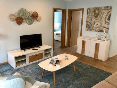 a living room with a television and a table at Casa da Miragaia in Angra do Heroísmo