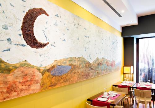 a restaurant with a large painting on the wall at Hospedium Hotel Posada De La Luna in Huesca