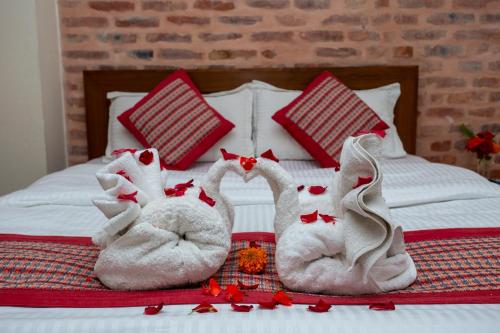 two towelsrendered to look like swans sitting on a bed at Kathmandu Boutique Hotel in Kathmandu