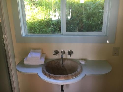 a sink in a bathroom with a window at Holualoa bungalows in Kailua-Kona