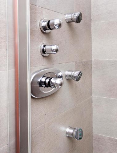 a shower door with a silver handle in a bathroom at Hospedium Hotel Posada De La Luna in Huesca