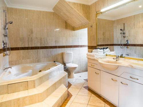 a bathroom with a tub and a toilet and a sink at U Suites on Courtenay in Wellington