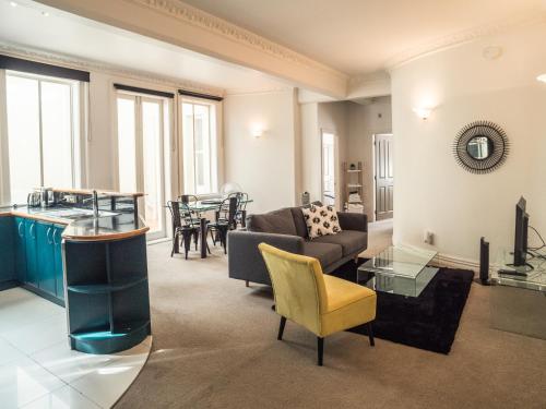 ein Wohnzimmer mit einem Sofa und einem Tisch in der Unterkunft U Suites on Manners in Wellington