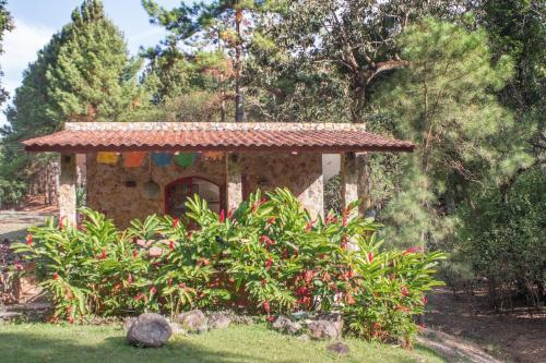 a small stone house in a garden with trees at VillaHermosa B&B in San Carlos