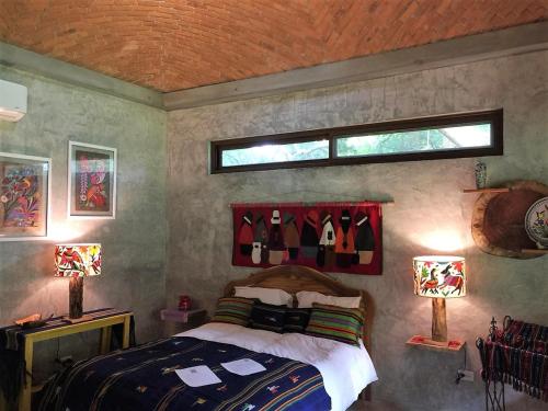 a bedroom with a bed and two lamps and a window at VillaHermosa B&B in San Carlos