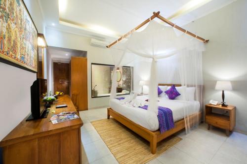a bedroom with a bed with a canopy at Puri Pandawa Resort in Uluwatu
