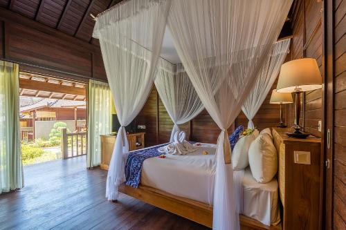 Een bed of bedden in een kamer bij Puri Pandawa Resort