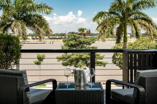a table with a glass of wine on a balcony at TAO Riverside Residence in Phnom Penh