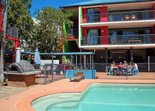 
people sitting in chairs at a pool at Beach Hostel Mooloolaba in Mooloolaba
