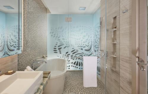 a bathroom with a sink, toilet and bathtub at Royal M Hotel & Resort Abu Dhabi in Abu Dhabi