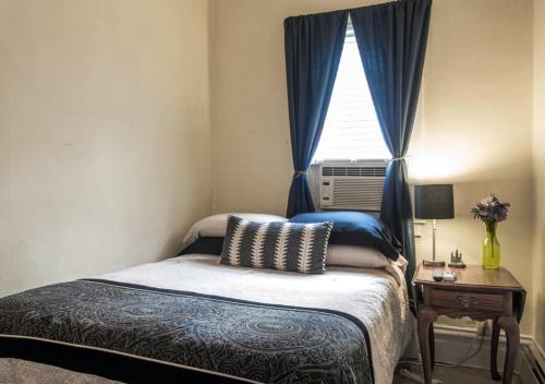 a small bedroom with a bed and a window at The Avondale Guesthouse in Chicago