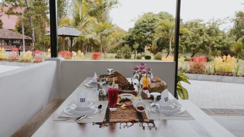 a table with plates and dishes on it on a balcony at Borobudur Bed & Breakfast in Borobudur
