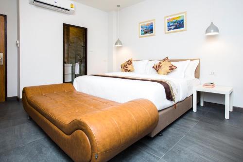 a bedroom with a large bed with a bench at V One Pride-Sukhumvit 22, Bangkok in Bangkok
