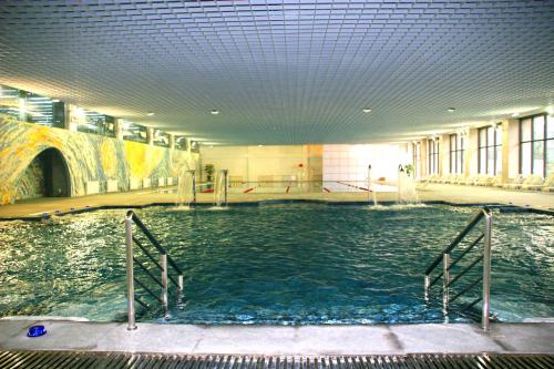 una gran piscina en un edificio con agua en Mercure Wanshang Beijing, en Beijing