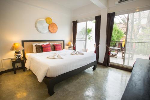 1 dormitorio con 1 cama grande y balcón en The Odyssey Chiang Mai, en Chiang Mai