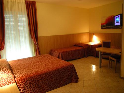 um quarto de hotel com duas camas e uma televisão em Hotel San Carlo em Mestre