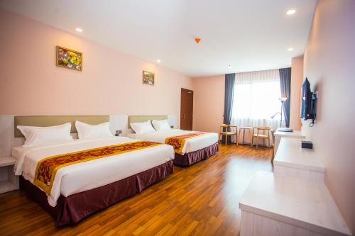 um quarto de hotel com duas camas e uma televisão em Austin Park Hotel em Johor Bahru