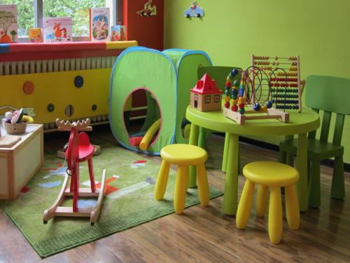 a childs play room with a table and stools at Familienhotel Citylight in Berlin