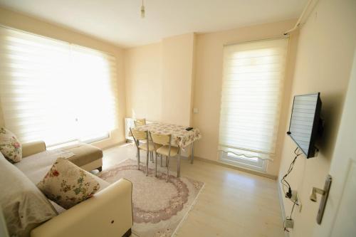 een woonkamer met een bank, een tafel en een televisie bij Serenity Apart in Kırklareli