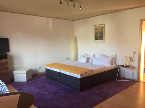 a bedroom with a large bed with a purple rug at Pension Jahn in Senftenberg