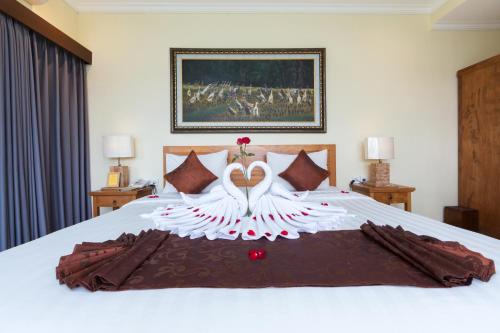 a bed with a wedding dress on top of it at Alamdini Resort Ubud in Ubud