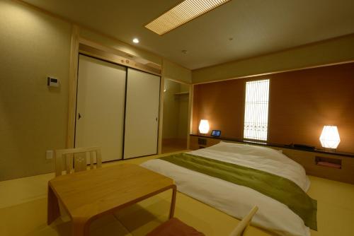 Un dormitorio con una cama grande y una mesa. en Hotel 5stars (Adult Only), en Takamatsu