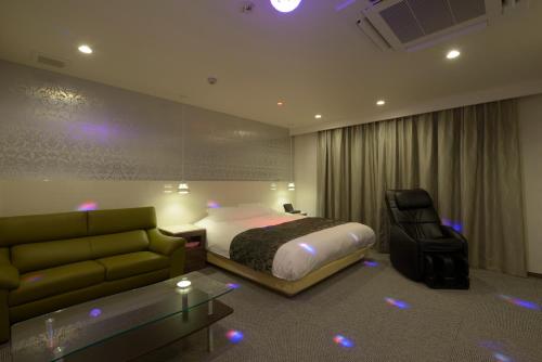 a hotel room with a bed and a couch at Hotel 5stars (Adult Only) in Takamatsu