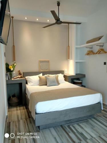 a bedroom with a large bed with a ceiling fan at Waterside Apartments in Ayia Evfimia
