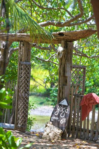 a sign on a wooden fence next to a tree at Kitesurfing Lanka in Kalpitiya