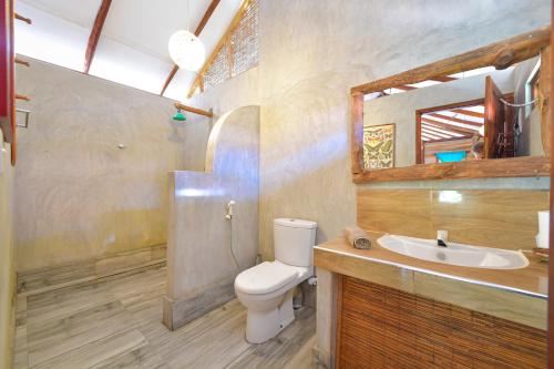 a bathroom with a toilet and a sink and a mirror at Kitesurfing Lanka in Kalpitiya