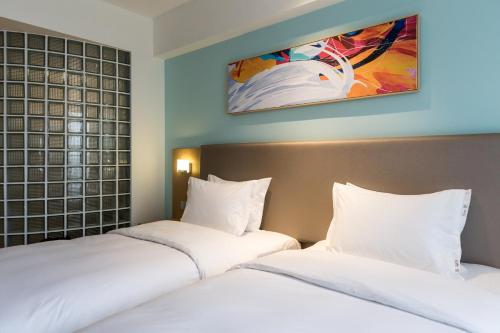 two beds sitting next to each other in a bedroom at Holiday Inn Express Chengdu Xindu by IHG in Chengdu