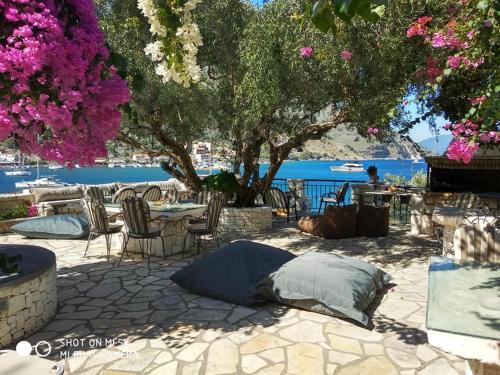 a patio with tables and chairs with a view of the water at Waterside Apartments in Ayia Evfimia