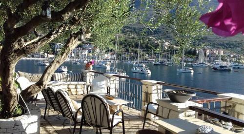 a patio with chairs and tables and a marina at Waterside Apartments in Ayia Evfimia