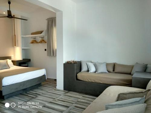 a living room with a bed and a couch at Waterside Apartments in Ayia Evfimia