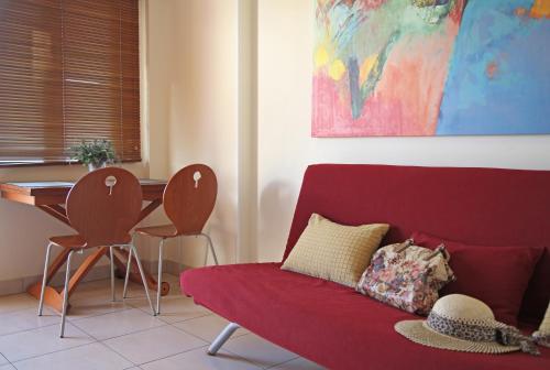 a living room with a red couch and a table at Sitia Bay in Sitia