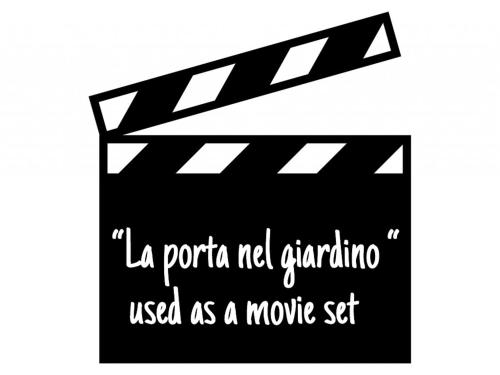 a black and white sign with a movie set at La Porta Nel Giardino in Asti