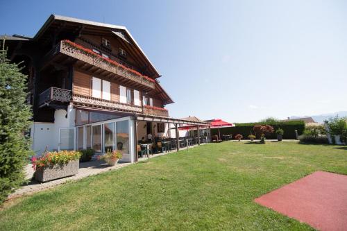 a large building with a lawn in front of it at Hôtel - Restaurant Le Manoir in Vaulruz