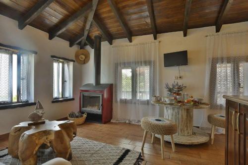 a living room with a fireplace and a table at Agkaze in Palaios Panteleimon