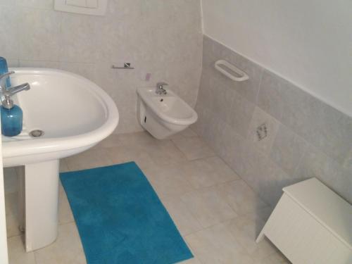bagno con lavandino bianco e tappeto blu di Casa Vacanze "Boccasile" a Bari