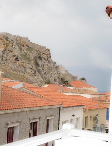 a group of buildings with red roofs and a mountain at Hotel Astron in Mirina
