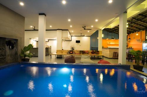 a large swimming pool in a living room at Noni Tree Hostel in Siem Reap