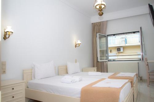 a bedroom with two beds and a window at Hotel Astron in Mirina