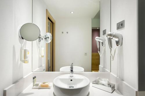 a bathroom with a sink and a mirror at Sercotel Ciudad de Miranda in Miranda de Ebro