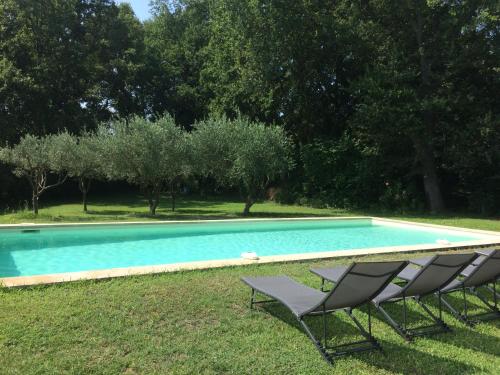 2 sillas y una piscina en el césped en Les Amarines, en Saint-Rémy-de-Provence