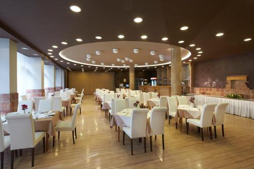 un comedor con mesas blancas y sillas blancas en Laterum Economy en Pécs