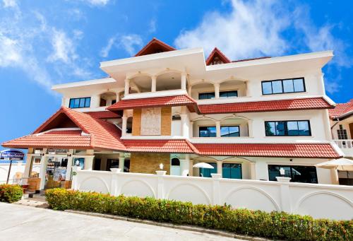 a white house with a red roof at Royal Prince Residence, Patong Beach in Patong Beach